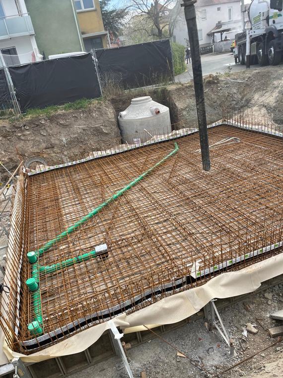 Bewehrte Bodenplatte mit verlegten Leitungen vor dem Betonieren